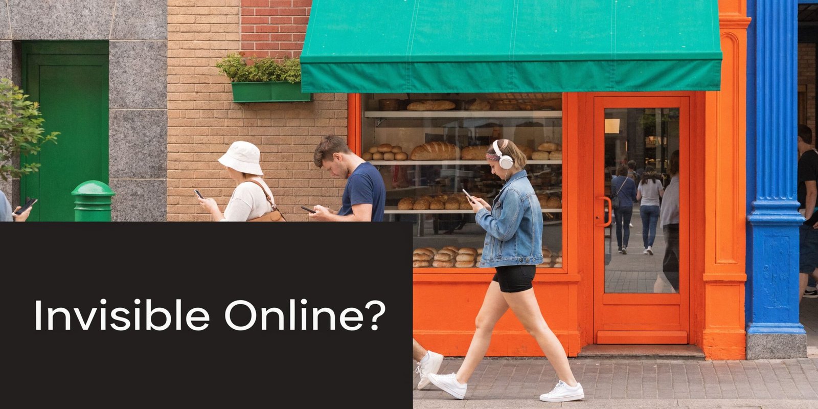 A diverse group of young people walking down a city street while focusing intently on their smartphones.