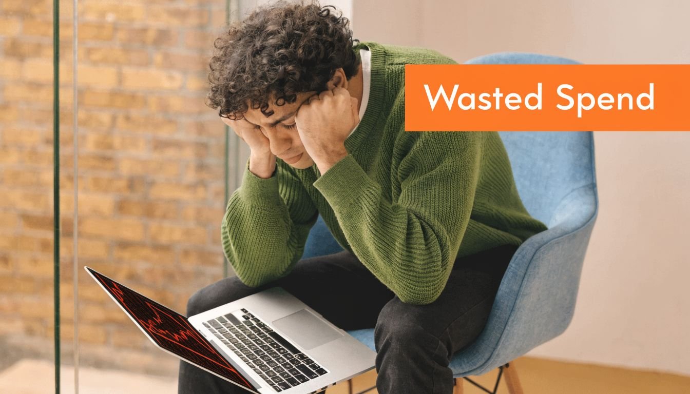 A young man looking stressed while sitting on a chair looking at his laptop computer screen.