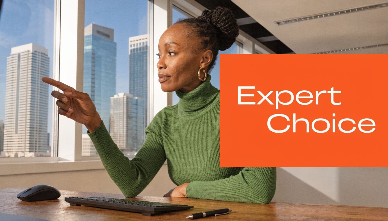 A professional woman in a green turtleneck pointing toward a city view from a modern office building.